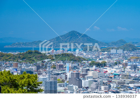 A panoramic view of the Seto Inland Sea and Gogoshima Island from Matsuyama Castle, and the city of Matsuyama enveloped in fresh greenery. A panoramic view of the Seto Inland Sea and Gogoshima Island from Matsuyama Castle, and the city of Matsuyama enveloped in fresh greenery. 138936037