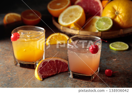 Cocktails with ice, grapefruit juice, and orange juice garnished with maraschino cherry. Cocktails with ice, grapefruit juice, and orange juice garnished with maraschino cherry. 138936042
