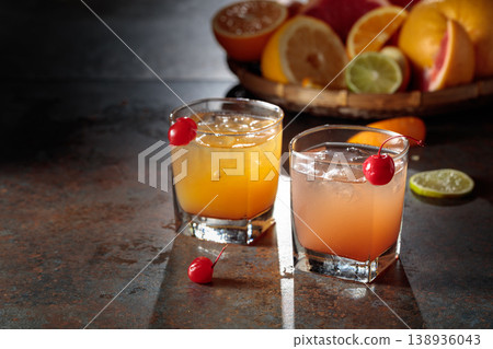 Cocktails with ice, grapefruit juice, and orange juice garnished with maraschino cherry. Cocktails with ice, grapefruit juice, and orange juice garnished with maraschino cherry. 138936043