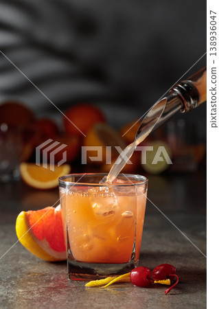Grapefruit juice is poured into a glass with ice. 138936047