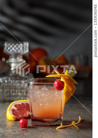 Cocktail with ice and grapefruit juice garnished with maraschino cherry. 138936048