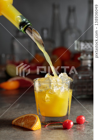 Orange juice poured into a glass with ice. 138936049