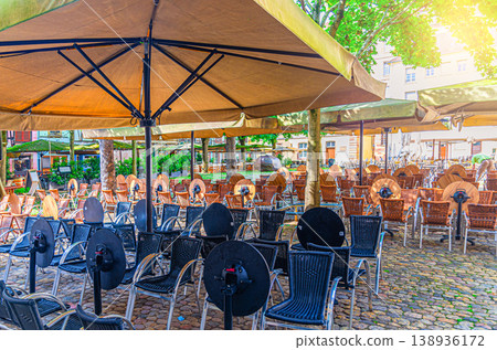Rows of tables, chairs and umbrellas of street restaurant outdoor cafe Rows of tables, chairs and umbrellas of street restaurant outdoor cafe 138936172