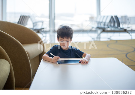 Young Boy Engaged in Creative Drawing at Airport Lounge with Modern Design Young Boy Engaged in Creative Drawing at Airport Lounge with Modern Design 138936282
