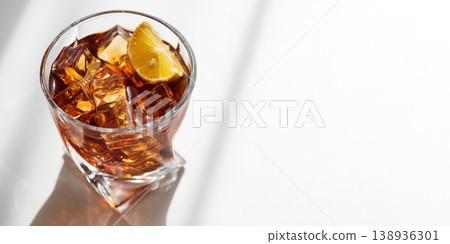 Cocktail with Whiskey, Cola and Lemon Garnish in Crystal Glass on White Wooden Background Cocktail with Whiskey, Cola and Lemon Garnish in Crystal Glass on White Wooden Background 138936301