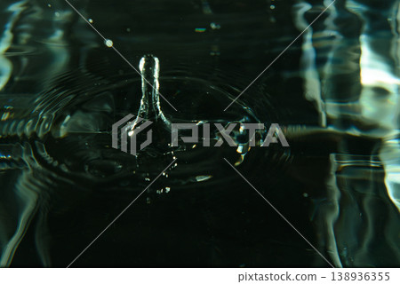 180.Water droplet splashing on a dark water surface 180.Water droplet splashing on a dark water surface 138936355