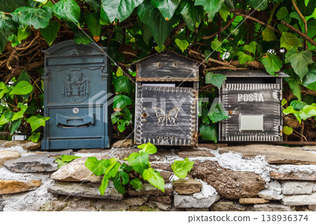 Three vintage mailboxes on stone wall surrounded by green ivy leaves in Italy Three vintage mailboxes on stone wall surrounded by green ivy leaves in Italy 138936374