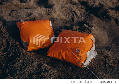 Inflatable armbands on sandy beach Child water safety concept swimming protection and learning basics of safe behavior near sea Inflatable armbands on sandy beach Child water safety concept swimming protection and learning basics of safe behavior near sea 138936414