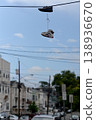 City Shoes Scene. Casual Sneakers Dangle Over Quiet Urban Neighborhood Under Clear Blue Sky 138936670