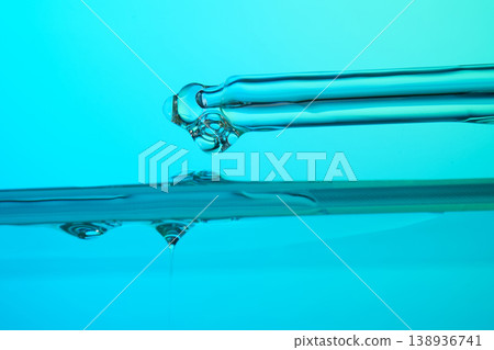 Pipette dripping liquid drop on turquoise water surface Pipette dripping liquid drop on turquoise water surface 138936741