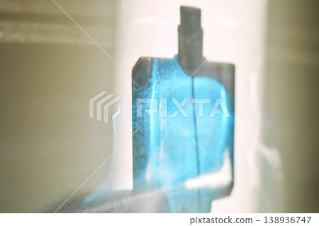Perfume bottle silhouette glowing with blue liquid Perfume bottle silhouette glowing with blue liquid 138936747