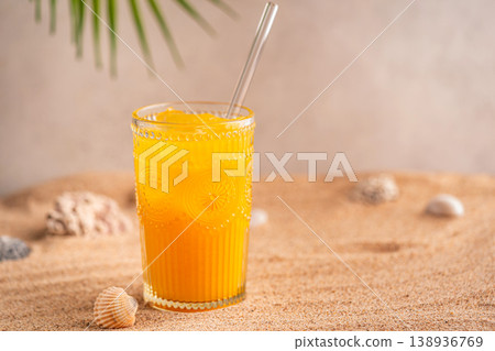 Colourful orange cocktail in a tall glass on a sand 138936769