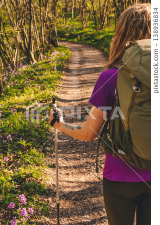 Female Hiker with Backpack and Trekking Poles Walking in Forest Female Hiker with Backpack and Trekking Poles Walking in Forest 138936834