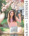 Stylish young woman standing under blooming magnolia trees in a Prague park. A modern take on fashion, nature, and city vibes in spring 138936924