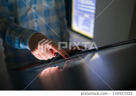 Woman using interactive touchscreen display at modern museum or exhibition 138937022