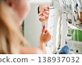 Female patient admires healthy teeth in mirror at dental office. Close up reflection with treatment unit in background. Useful for clinic advertising, cosmetic dentistry branding, wellness visuals 138937032