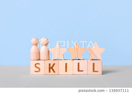 Wooden cubes with the word skill, wooden stars, and people on a blue background. Skill competency development concept. Education learning talent, up new ability training technology evolution. 138937111