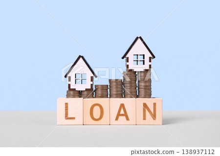 Wooden blocks with the word loan, stacks of coins symbolizing an upward graph, and wooden houses. Personal loan assessment. Car, house, personal money loan concept. Wooden blocks with the word loan, stacks of coins symbolizing an upward graph, and wooden houses. Personal loan assessment. Car, house, personal money loan concept. 138937112