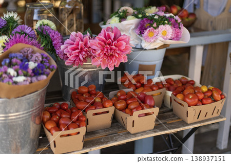 Colorful Fresh Tomatoes and Floral Bouquets at a Vibrant Market Stall 138937151