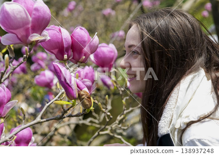 Woman enjoying cherry blossoms in a tranquil Japanese garden. Blossom delight. 138937248