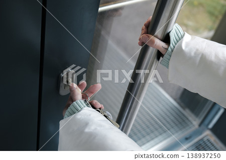 A person opening a door with a key creates a moment of transition from public to private space, comfort and familiarity. 138937250