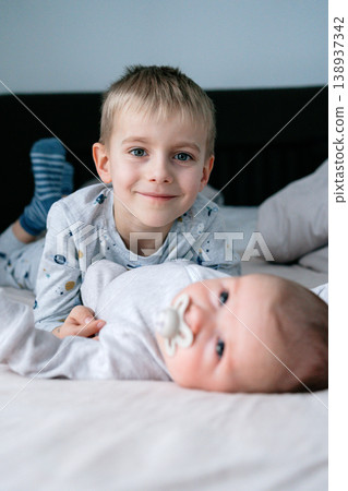 Smiling child lying next to newborn baby. Concept of happiness, family, childhood and emotional connection 138937342