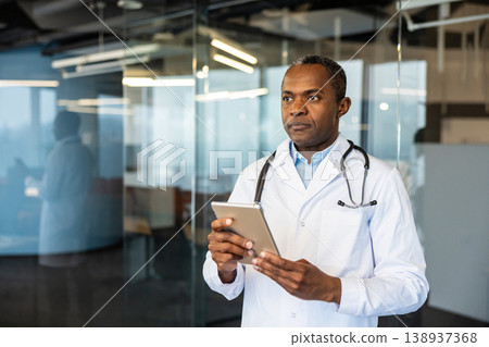 Medical doctor in lab coat with stethoscope stands in clinic reviewing patient data on a digital tablet, focused on telemedicine, digital healthcare and clinical decision-making Medical doctor in lab coat with stethoscope stands in clinic reviewing patient data on a digital tablet, focused on telemedicine, digital healthcare and clinical decision-making 138937368