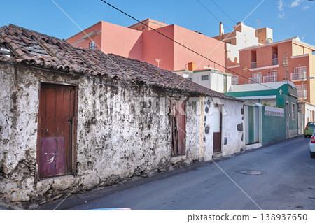 Exterior of decaying brick buildings with peeling paint in a street of Santa Cruz de La Palma. Architectural details of an abandoned rustic property with damaged and aged doors or entrances outside Exterior of decaying brick buildings with peeling paint in a street of Santa Cruz de La Palma. Architectural details of an abandoned rustic property with damaged and aged doors or entrances outside 138937650