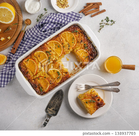 traditional greek orange pie on the plate and in the baking dish - Portokalopita with thyme 138937703