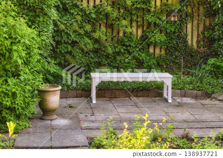 Gardeners corner. Private chair in green garden in the beautiful outdoors. A place with green nature views outside. Resting area for relaxation and isolated seating area surrounded by natural life. Gardeners corner. Private chair in green garden in the beautiful outdoors. A place with green nature views outside. Resting area for relaxation and isolated seating area surrounded by natural life. 138937721