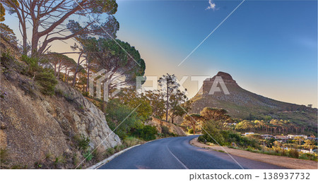 An empty road on the mountain at sunrise. Street overlooking mountain peak with a scenic view of the city from a street on the mountain at sunset. The landscape of a beautiful view of Lions head An empty road on the mountain at sunrise. Street overlooking mountain peak with a scenic view of the city from a street on the mountain at sunset. The landscape of a beautiful view of Lions head 138937732