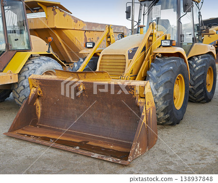 Bulldozers at a construction site parked after operating. Huge orange powerful building vehicle with a hydraulic piston scoop and black wheels. Heavy machinery outside in an empty space Bulldozers at a construction site parked after operating. Huge orange powerful building vehicle with a hydraulic piston scoop and black wheels. Heavy machinery outside in an empty space 138937848
