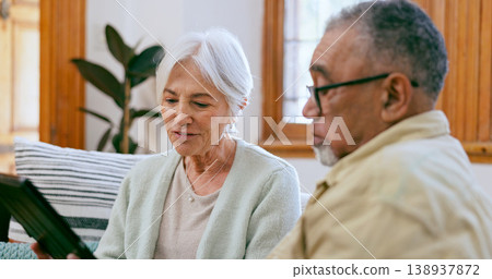 Tablet, love and a senior couple on a sofa in the living room of their home to search social media together. Interracial, app or tech with an elderly man and woman in the apartment for retirement Tablet, love and a senior couple on a sofa in the living room of their home to search social media together. Interracial, app or tech with an elderly man and woman in the apartment for retirement 138937872