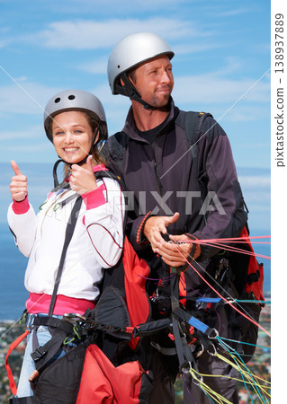 People, thumbs up and outdoor in nature for paragliding, extreme sport and portrait in sunshine. Man, woman and fitness on adventure with helmet, agreement or parachute with yes, review and blue sky 138937889