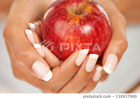 Hands, apple or food with a person closeup for health, diet or nutrition in the kitchen of her home. Fruit, nutritionist and hunger with an adult eating fresh produce for a healthy weight loss snack 138937900