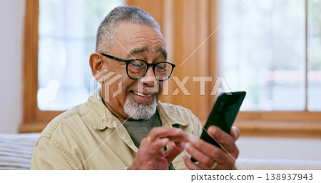 Phone, smile and social media with a senior man on a sofa in the living room of his home for retirement. Relax, app and a happy elderly person in an apartment for communication on his mobile 138937943