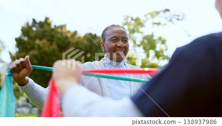 Elderly woman, stretching band and nurse outdoor for exercise, workout or fitness in a park with smile. People, professional or caregiver with physical activity for physiotherapy, wellness and health Elderly woman, stretching band and nurse outdoor for exercise, workout or fitness in a park with smile. People, professional or caregiver with physical activity for physiotherapy, wellness and health 138937986