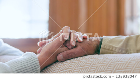 Comfort, support and senior couple holding hands in living room at modern home for romance and compassion. Love, empathy and closeup of elderly man and woman with affection in the lounge of a house. Comfort, support and senior couple holding hands in living room at modern home for romance and compassion. Love, empathy and closeup of elderly man and woman with affection in the lounge of a house. 138938047
