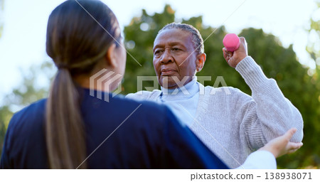 Dumbbell, exercise and a senior black woman with a nurse outdoor in a garden together for physiotherapy. Fitness, health or wellness with an elderly patient and medical nurse in the yard to workout Dumbbell, exercise and a senior black woman with a nurse outdoor in a garden together for physiotherapy. Fitness, health or wellness with an elderly patient and medical nurse in the yard to workout 138938071
