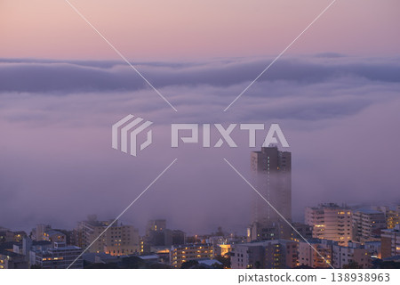 Panoramic view of clouds covering buildings at sunset in the popular city of Cape Town, South Africa with copy space. A peaceful, misty sunrise over signal hill. Landscape of a modern town at night 138938963
