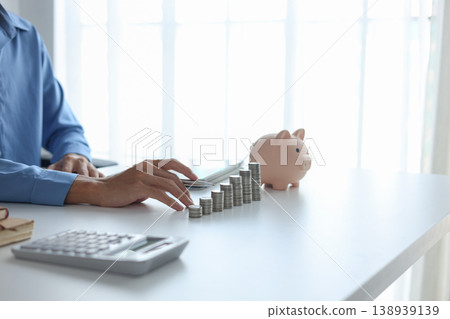 Businessman calculating saving and growing capital on office desk. 138939139