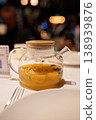 Glass teapot with citrus fruit infusion on table in restaurant setting with blurred background 138939876