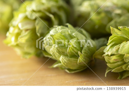 乾燥的啤酒花球果擺放在木桌上,散發出啤酒釀造原料啤酒花的香氣和苦味。 乾燥的啤酒花球果擺放在木桌上,散發出啤酒釀造原料啤酒花的香氣和苦味。 138939915