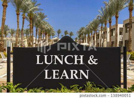 Lunch and learn symbol. Concept words Lunch and learn on beautiful big black road sign. Beautiful blue sky palm trees background. Business, educational and lunch and learn concept. Copy space. 138940051