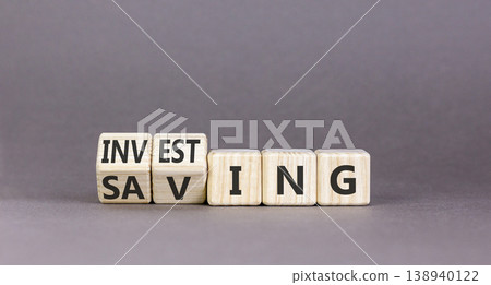 Investing and saving symbol. Concept words Saving to Investing on beautiful wooden cubes. Beautiful grey table grey background. Business, investing and saving concept. Copy space. Investing and saving symbol. Concept words Saving to Investing on beautiful wooden cubes. Beautiful grey table grey background. Business, investing and saving concept. Copy space. 138940122