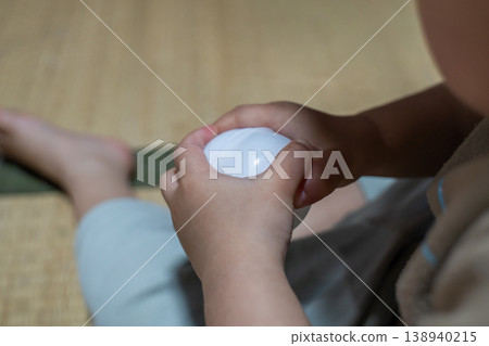一隻孩子的手打開了扭蛋機裡的膠囊。 一隻孩子的手打開了扭蛋機裡的膠囊。 138940215