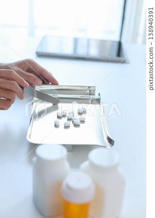 Healthcare Professional Organizing Prescription Medication with Spatula and Pill Tray. Healthcare Professional Organizing Prescription Medication with Spatula and Pill Tray. 138940391