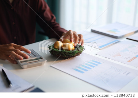 Businessman calculating and golden eggs on the table. wealth management and investment concept. Businessman calculating and golden eggs on the table. wealth management and investment concept. 138940738