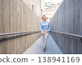 Confident businesswoman walking through modern 138941169