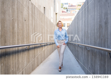 Confident businesswoman walking through modern Confident businesswoman walking through modern 138941169